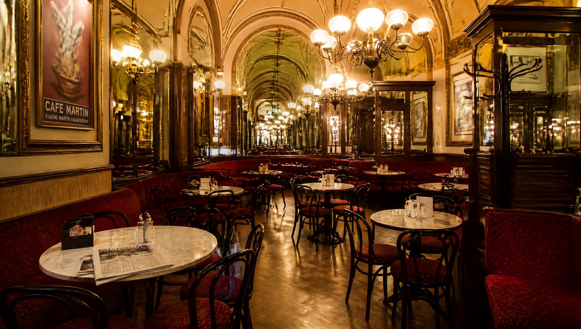 Elegantes Interieur des Viennastyle Café mit Kronleuchtern und Marmortischen